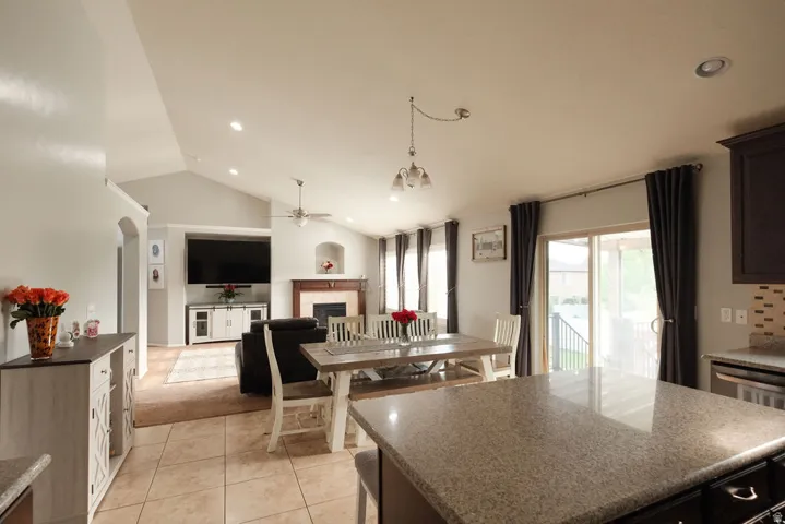 Open-concept living area with vaulted ceilings, recessed lighting, and tile flooring