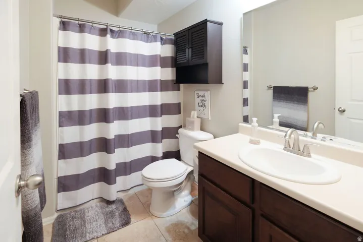 Bathroom featuring a vanity with a single basin sink, brushed nickel faucet, and a large wall-mounted mirror