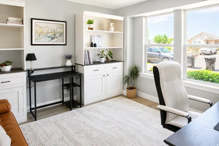 Built-in cabinetry with shelving, light-toned flooring, and large windows