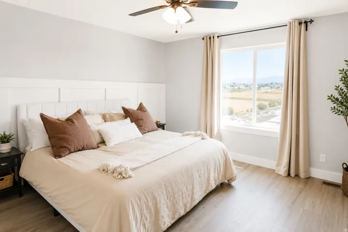 Expansive window with surrounding scenery, wood-finish flooring, ceiling fan with integrated lighting, and a paneled accent wall