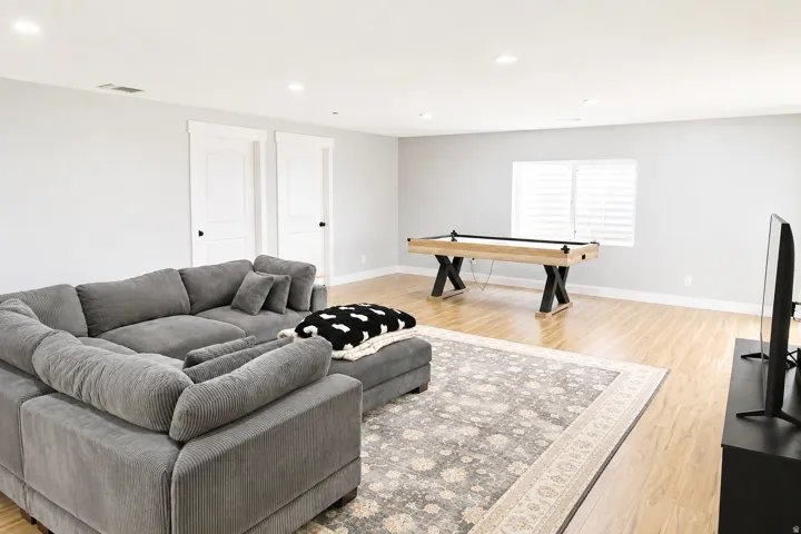 Spacious room featuring light wood-finish flooring, recessed lighting, and white walls