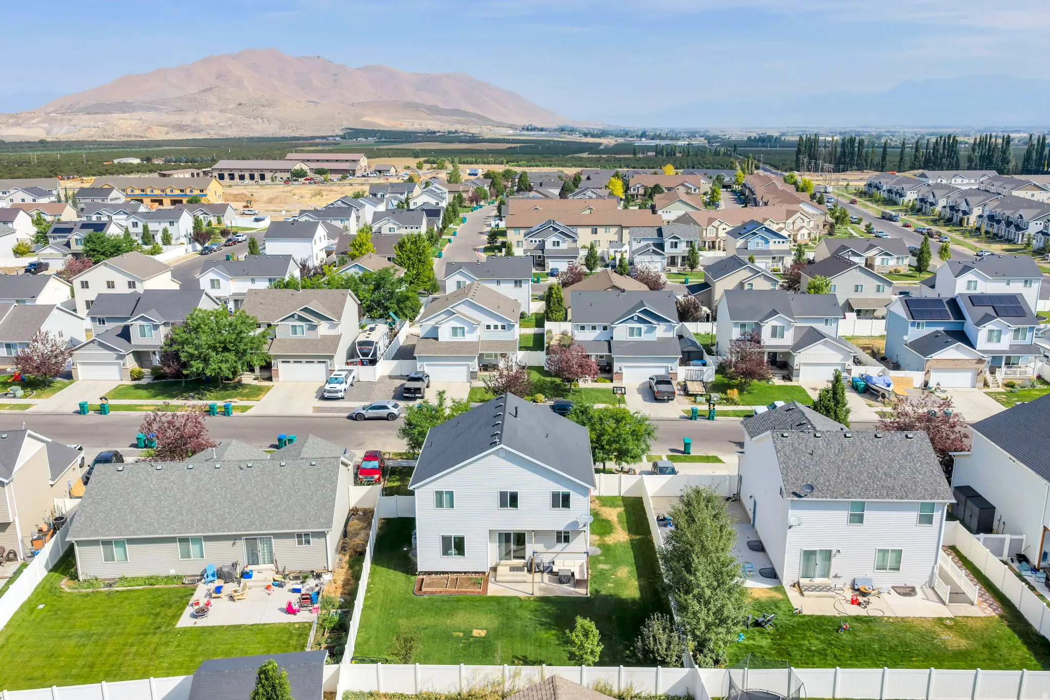 Expansive community with varied architectural styles, a mountainous backdrop, and mature landscaping