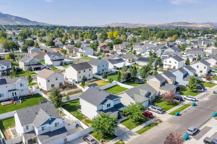 Aerial landscape showcasing a residential neighborhood with diverse housing styles, paved streets, and green landscaping