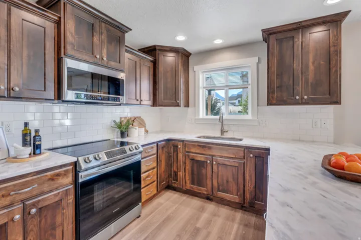 Warm wood cabinetry, subway tile backsplash, and quartzite countertops