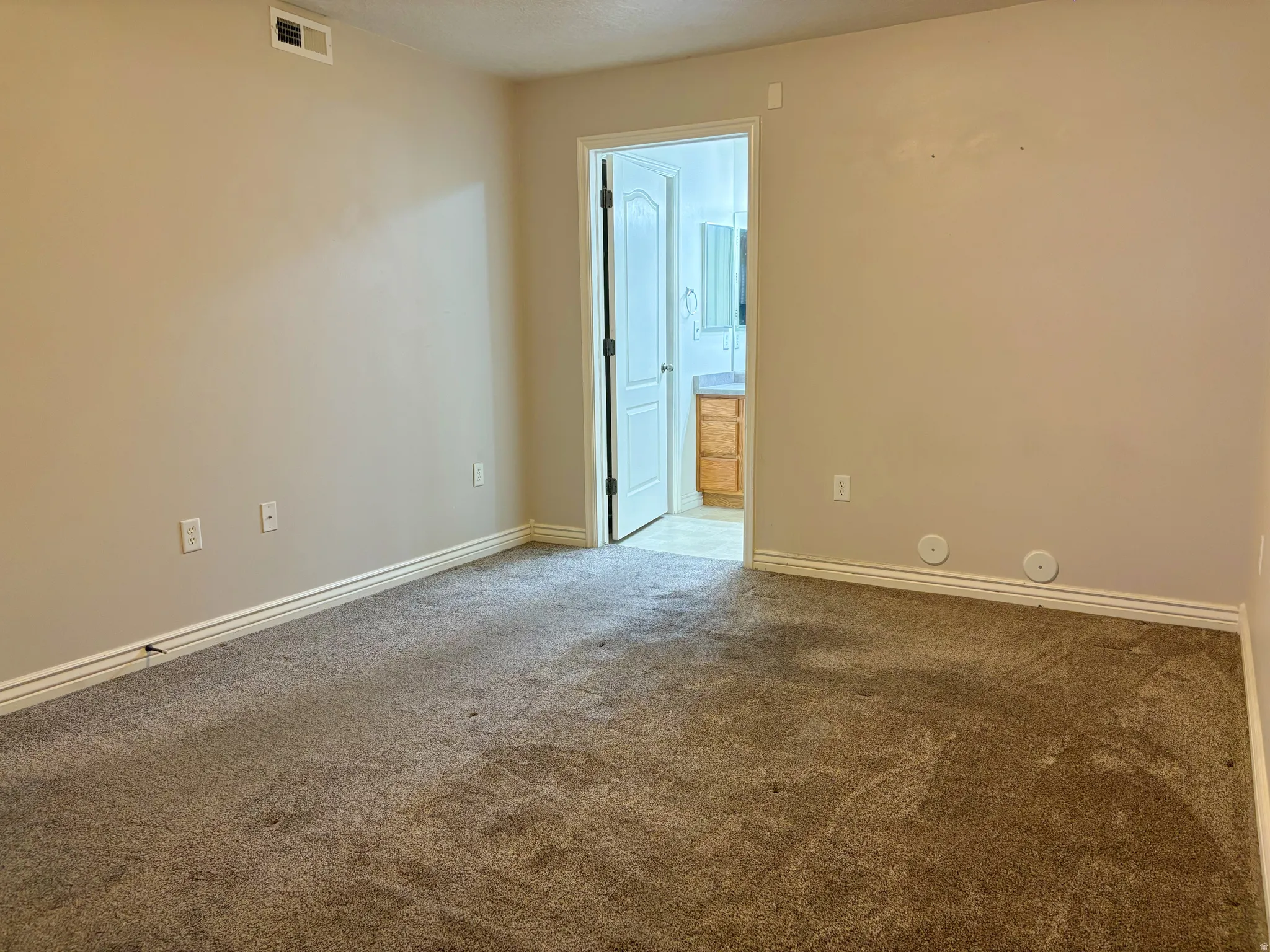 Plush carpet flooring complements neutral wall tones