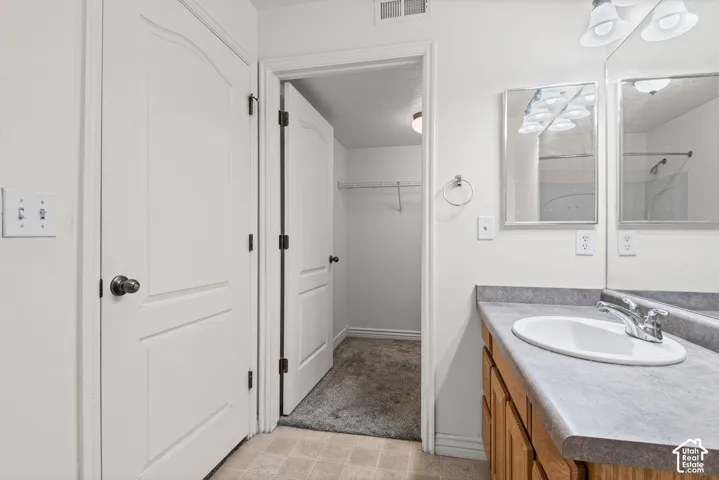 Vanity with a single basin sink, chrome faucet, and integrated counter space