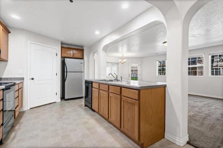 Kitchen featuring wood-finish cabinetry, stainless steel appliances, and a gray countertop island with integrated sink