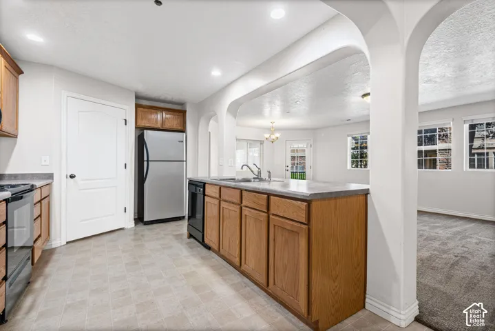 Kitchen featuring wood-finish cabinetry, stainless steel appliances, and a gray countertop island with integrated sink