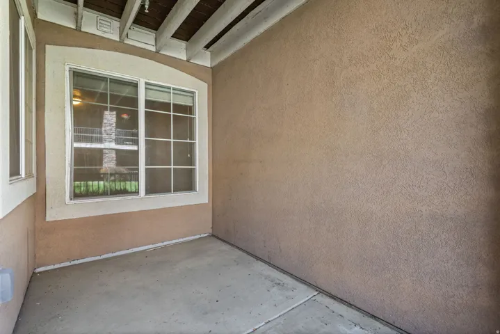 Covered patio with stucco walls and a smooth concrete floor