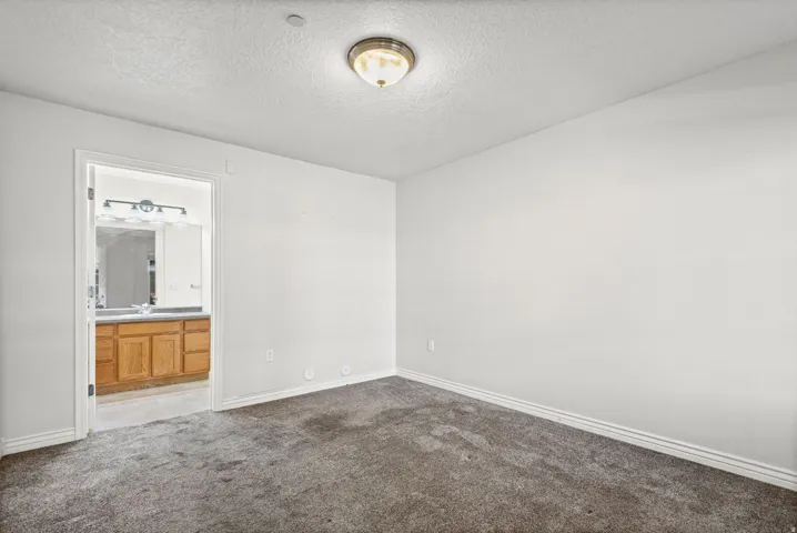 Neutral wall finishes, recessed ceiling light, and carpet flooring