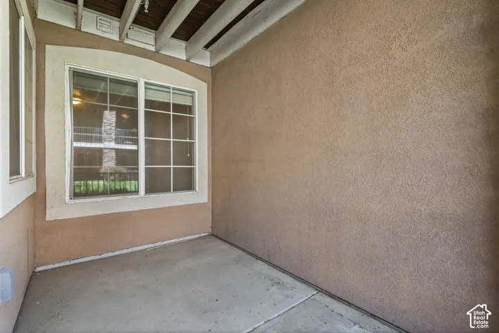 Covered patio with stucco walls and a smooth concrete floor