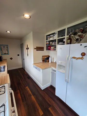 Wood-finish flooring, recessed lighting, wood countertops, and open shelving