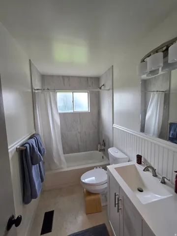 Bathtub with integrated shower, wall-mounted showerhead, and window