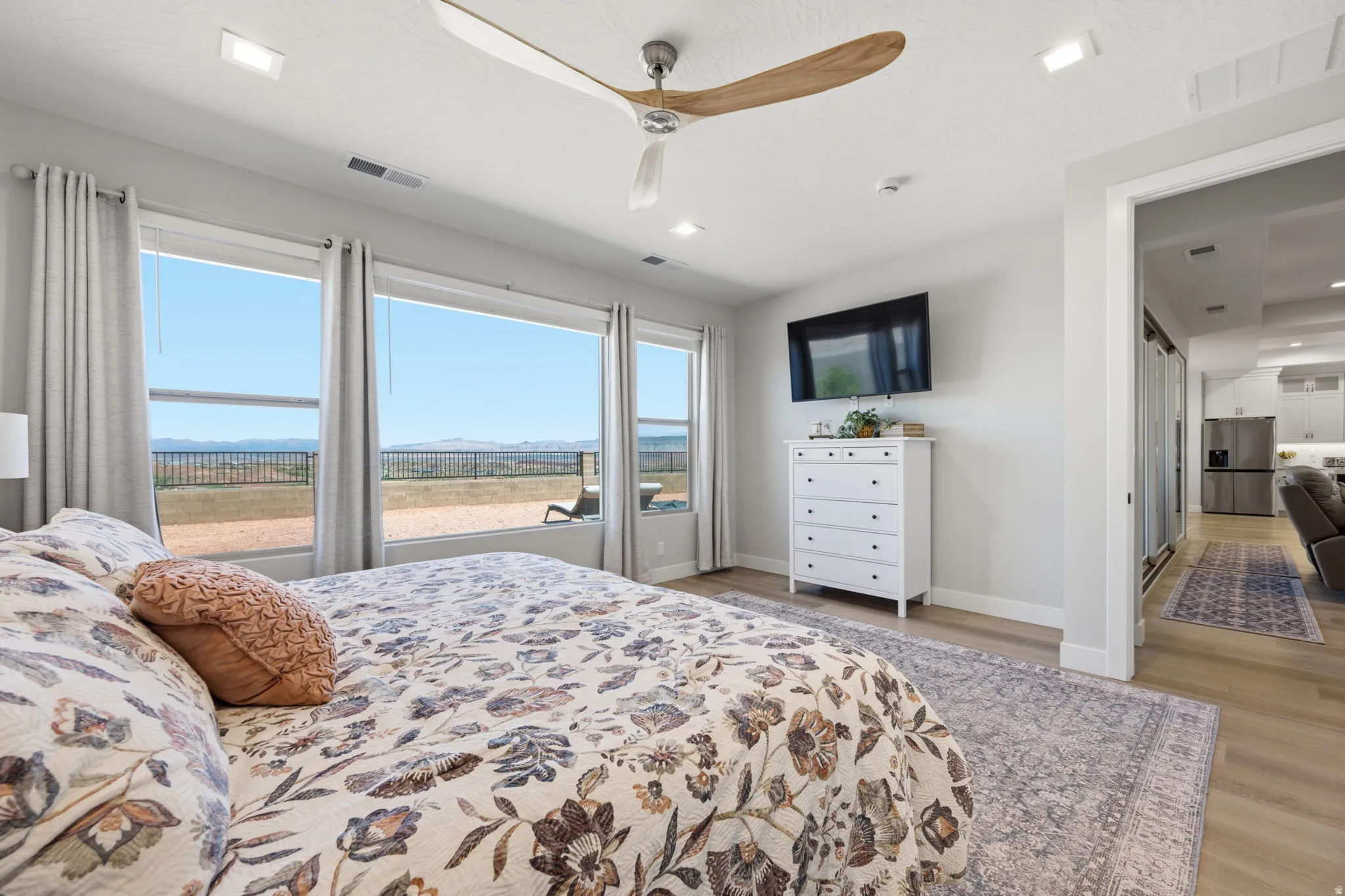 LVP wood-finish flooring, recessed lighting, and a ceiling fan with wood-tone blades