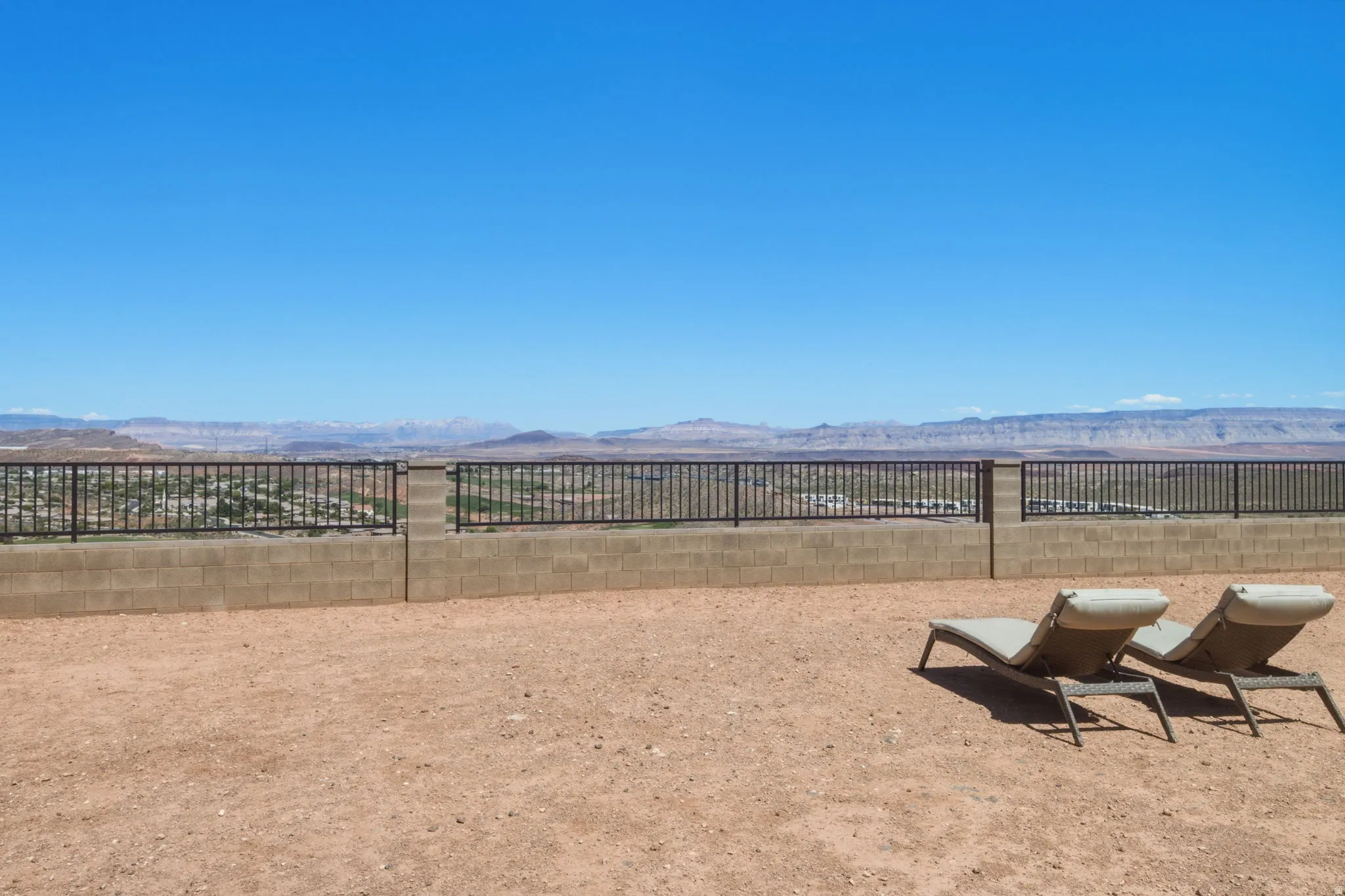 Desert landscape with a block wall and wrought iron fencing