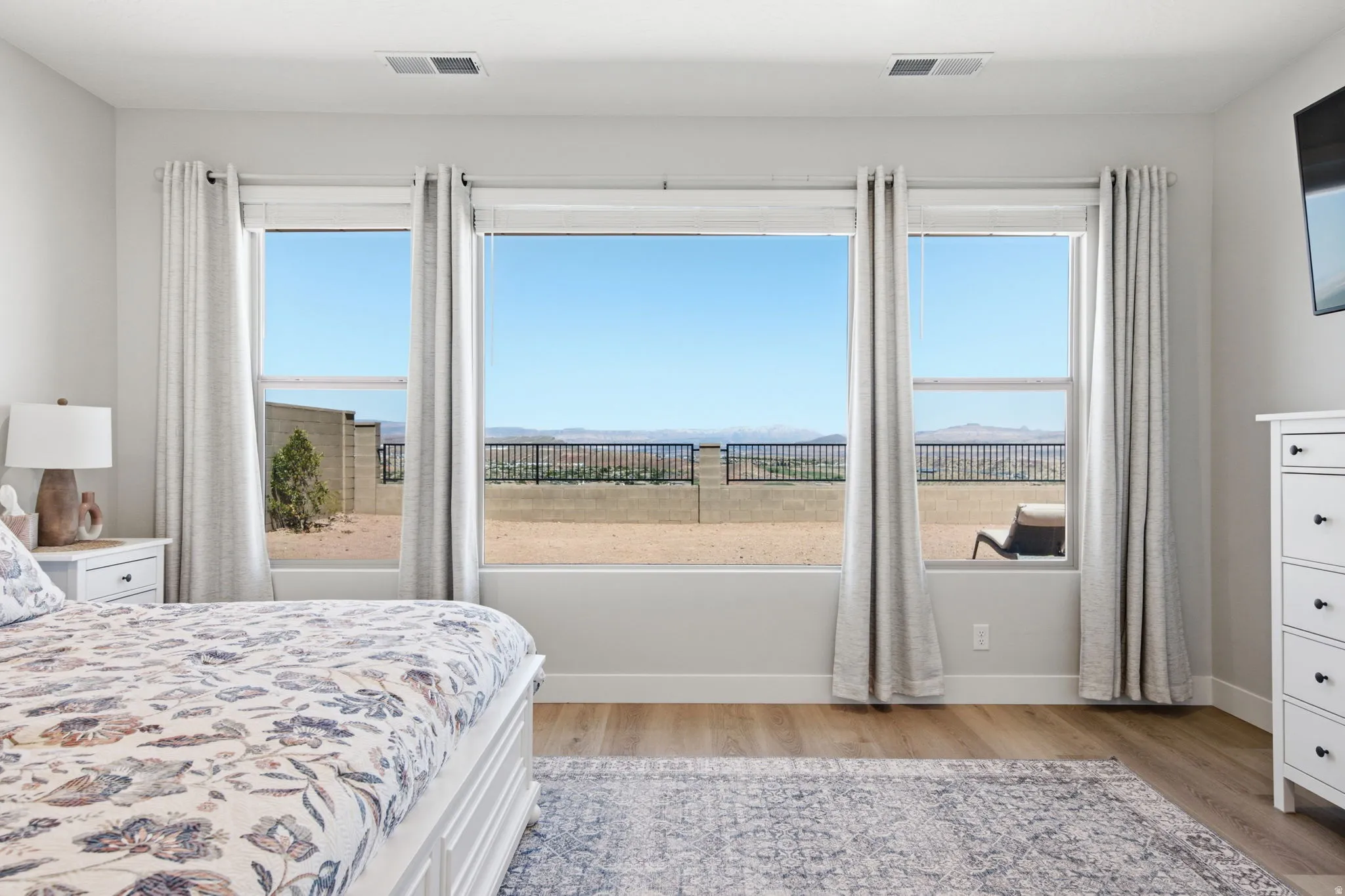 Wide windows with expansive desert scenery, LVP wood-finish flooring, and white walls