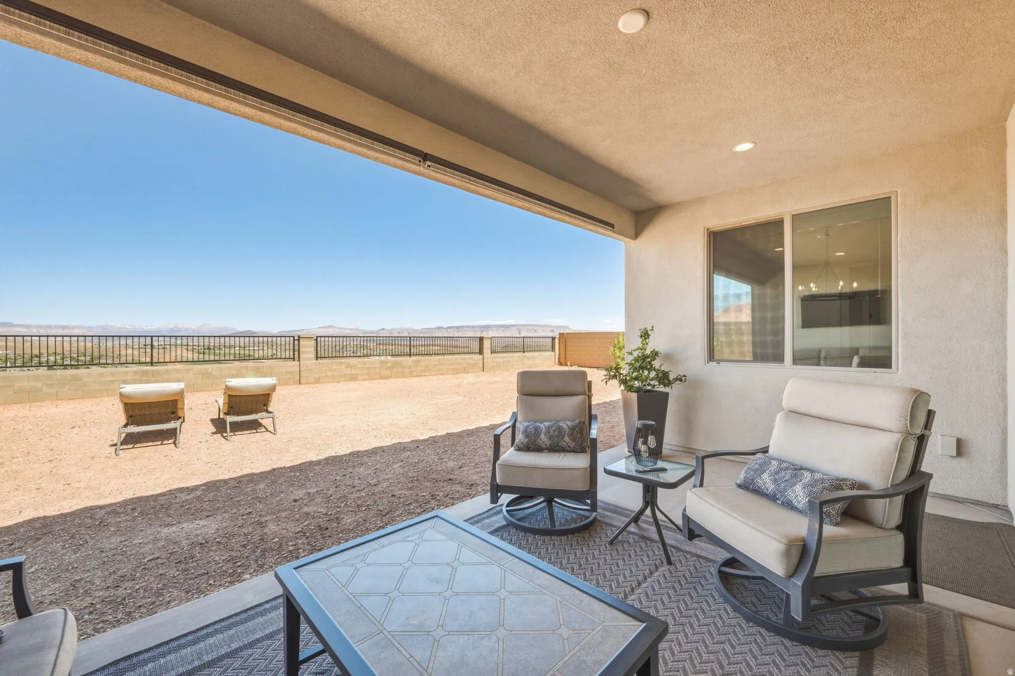 Covered outdoor patio , recessed lighting, T.V.  and an expansive desert landscape