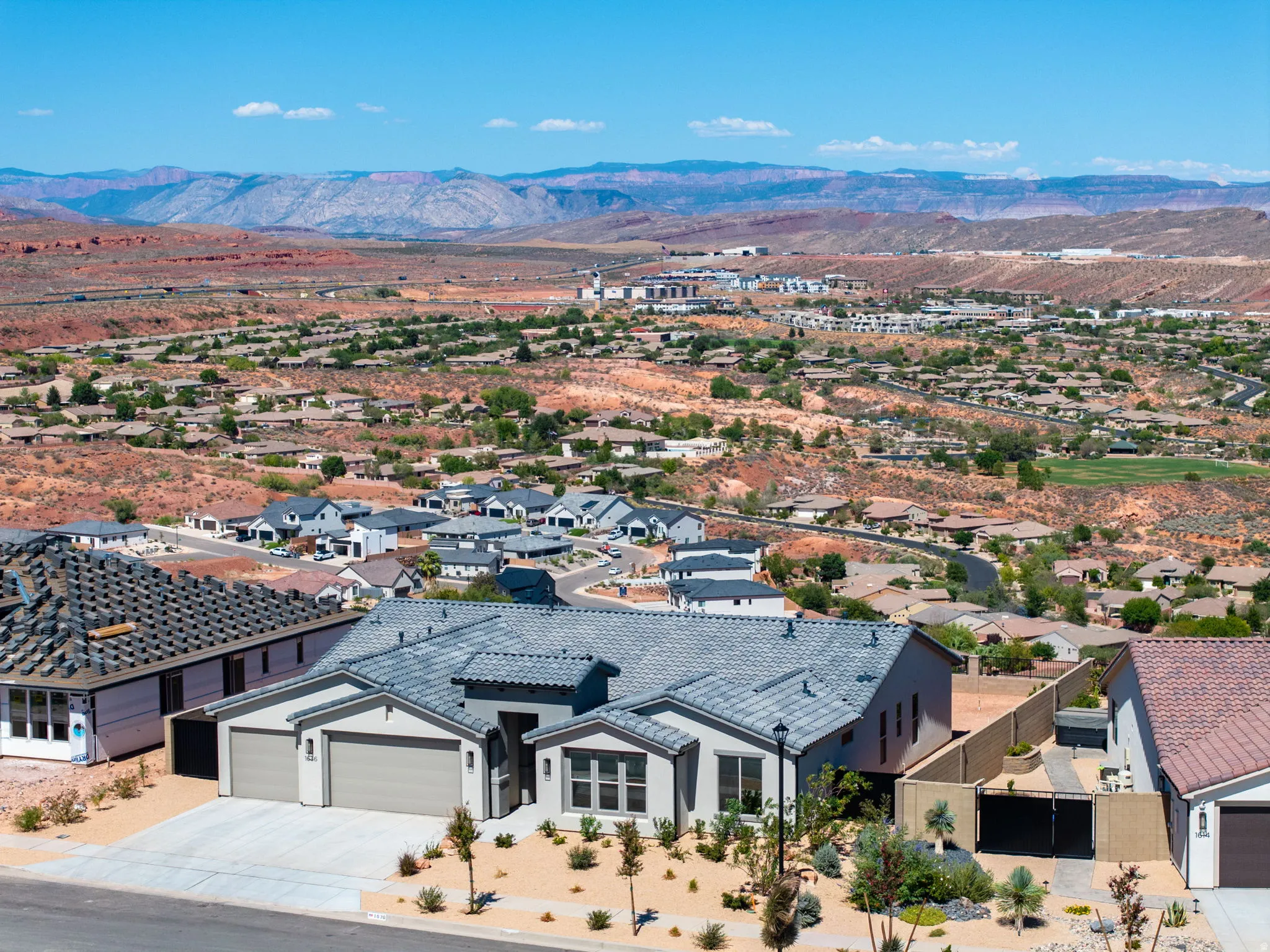 Contemporary exterior with a 3-car garage, low-maintenance landscaping, and a tile roof