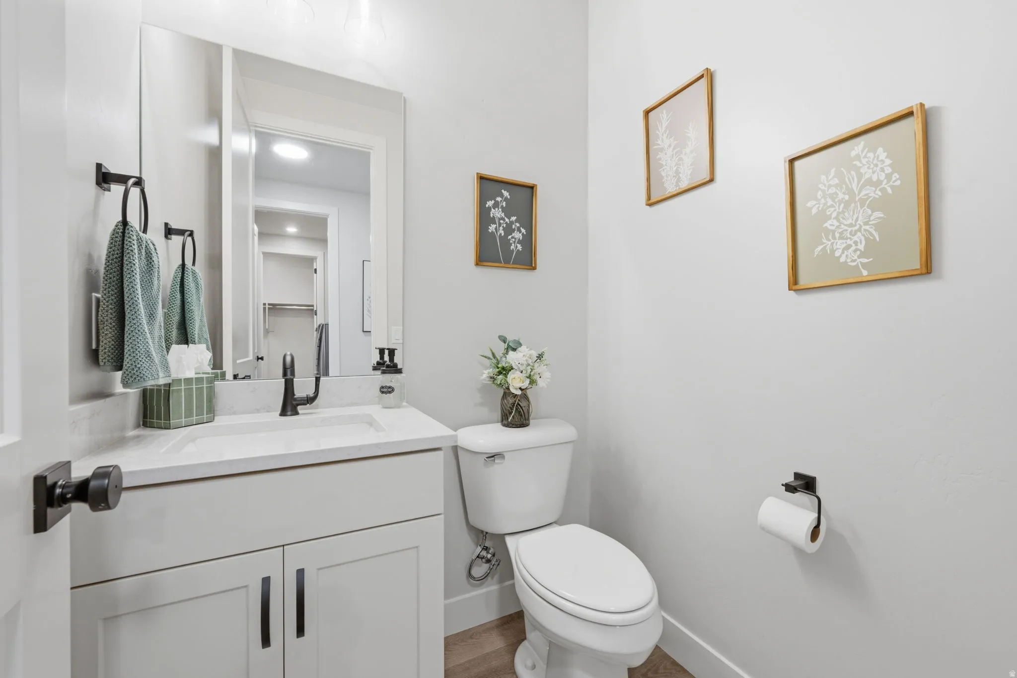 White vanity with shaker-style cabinetry, a rectangular undermount sink, and matte black hardware