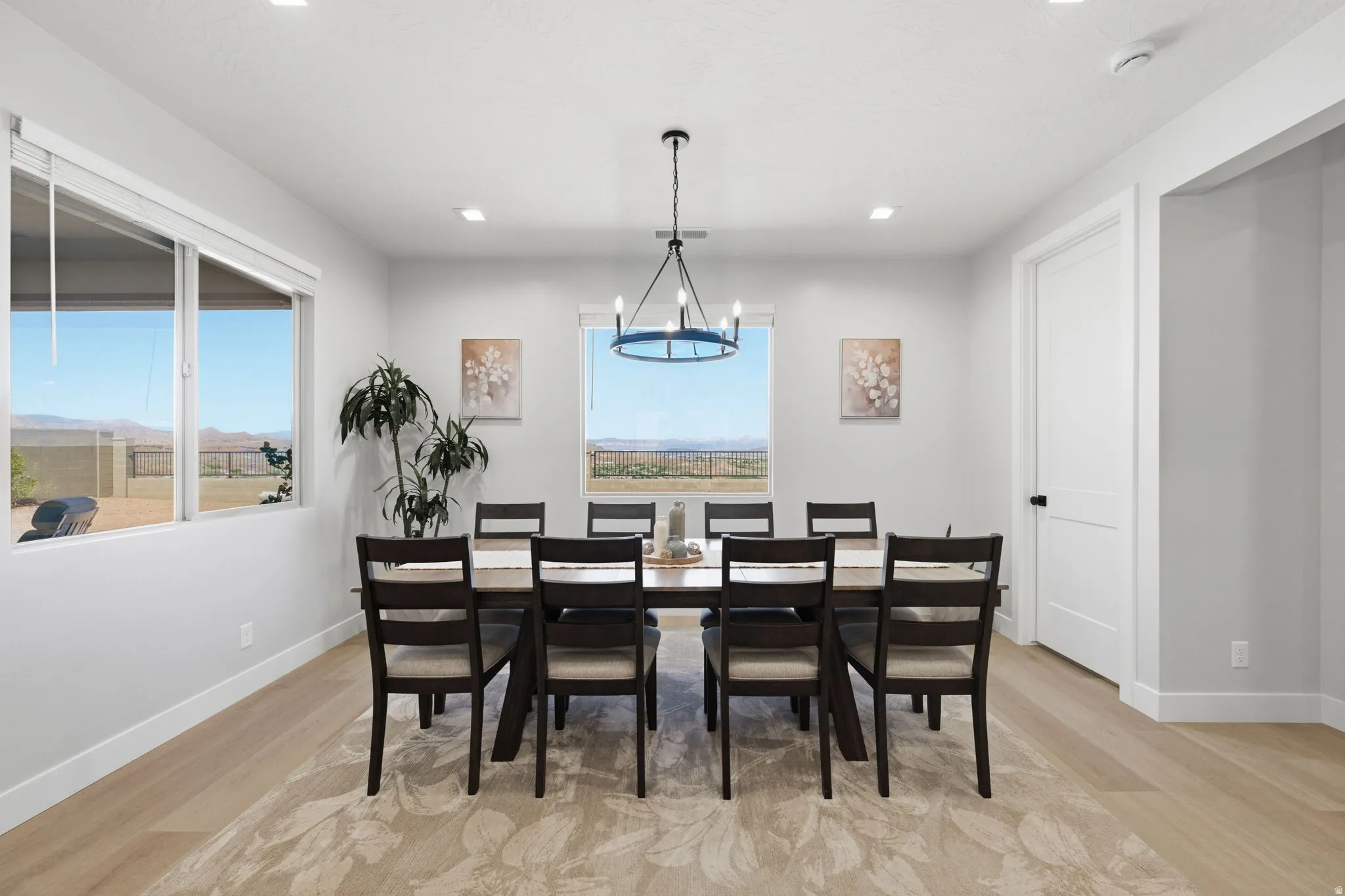 Expansive dining area featuring multiple windows, LVP wood-finish flooring, and recessed lighting