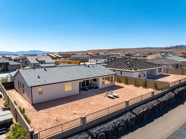 Expansive backyard space with block and wrought iron perimeter fencing,