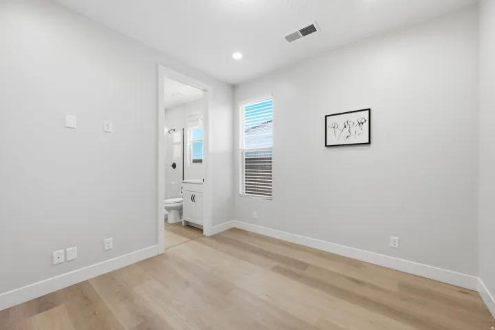 Recessed lighting, LVP wood-finish flooring, and a window with horizontal blinds