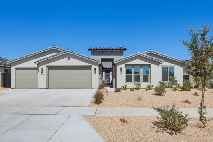 Contemporary stucco exterior with a tiled roof and an attached three-car garage