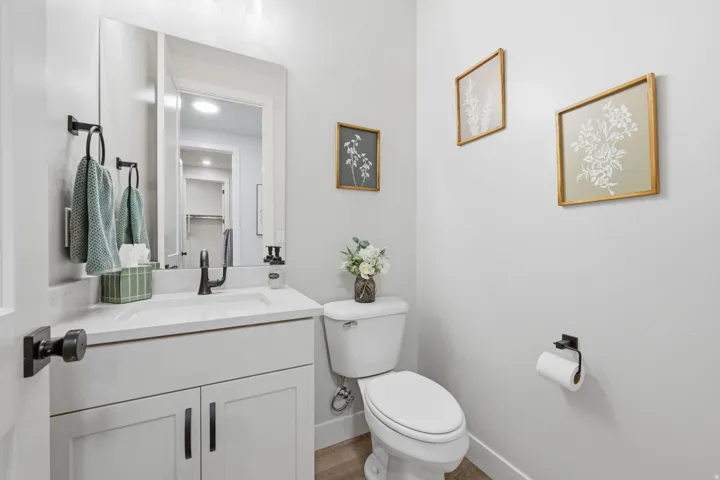 White vanity with shaker-style cabinetry, a rectangular undermount sink, and matte black hardware