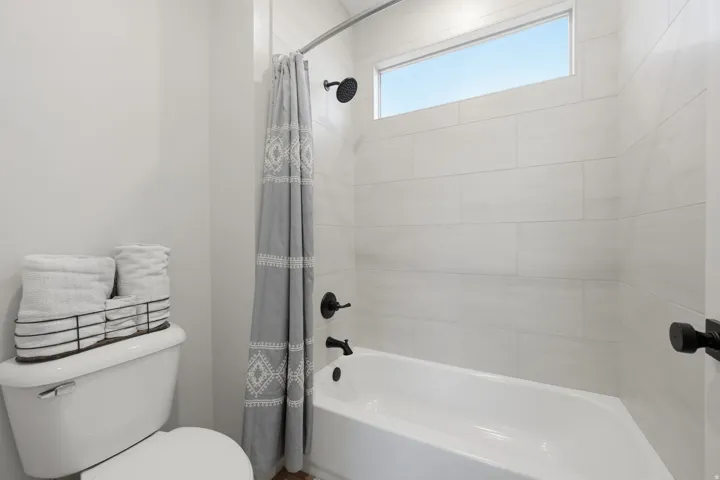 White subway tile shower surround with a built-in tub and matte black fixtures