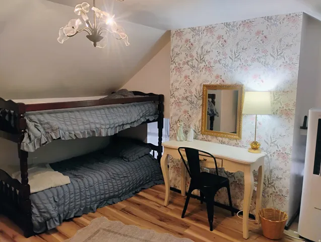 Wood-finish flooring, accent wall with floral wallpaper, and a built-in light fixture