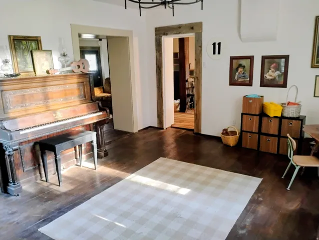 Hardwood flooring throughout, with a rustic wood-framed doorway and white wall finishes