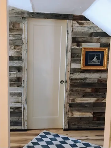 Reclaimed wood-finish wall paneling, solid wood door with paneling, wood-finish flooring