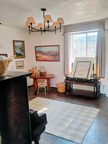 Hardwood flooring, window with natural light, ceiling-mounted chandelier