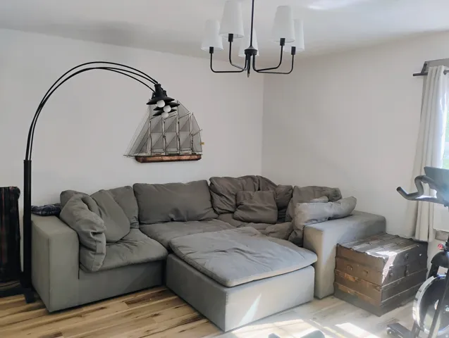 Recessed lighting, wood-finish flooring, white walls, and a window with curtain rod and drapes