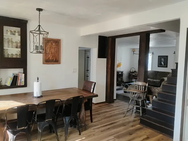 Wood-finish flooring, dark wood built-in cabinetry, wrought iron chandelier, and exposed wood beams