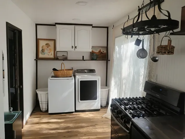 Wood-finish flooring, white walls, built-in shelving, white cabinetry, and a dark countertop