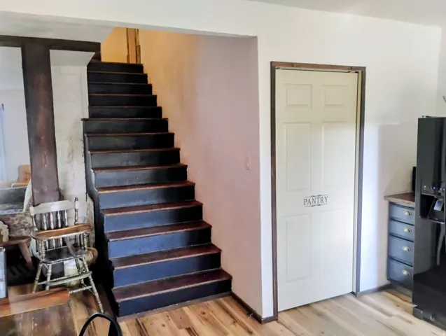 Dark-stained staircase with wood-finish flooring