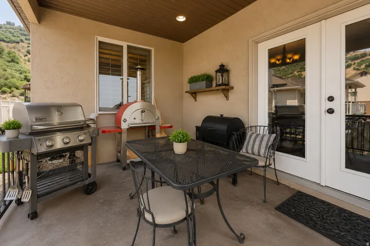 Covered patio featuring a textured floor, white French doors, and a wood-slat ceiling