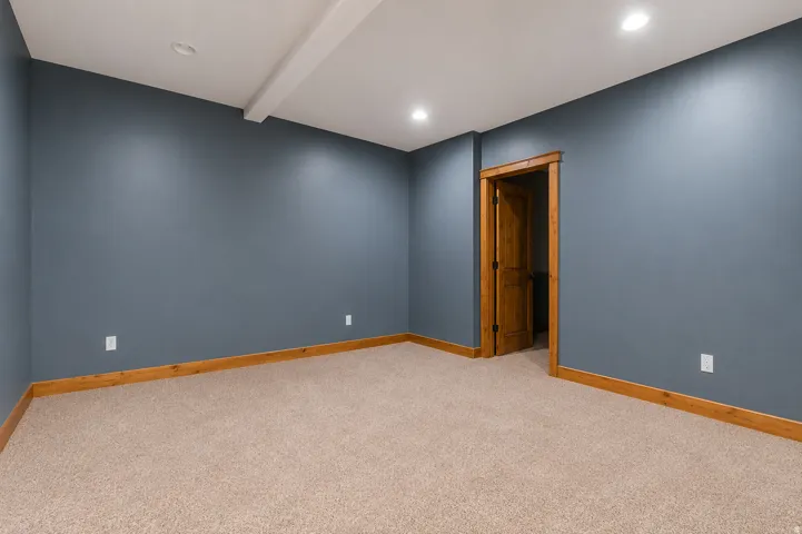 Recessed lighting, wood-finish trim, wood-finish door, and carpeted flooring