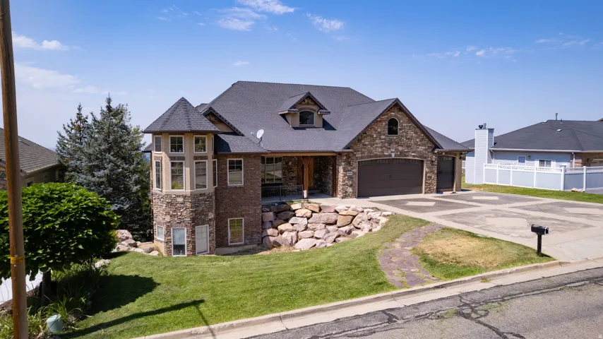 Stone and siding exterior with dark shingle roofing