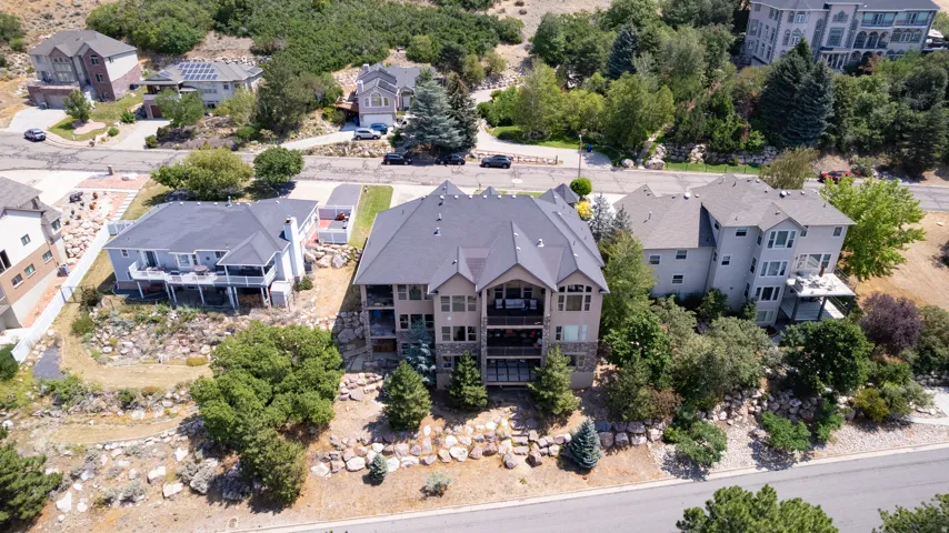 Multi-level property with balconies, a sloped lot, and mature trees