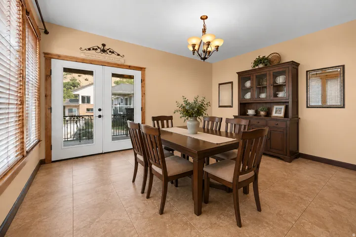 Tile flooring with a neutral finish, double glass-paneled doors, wood-trimmed windows with horizontal blinds, and a built-in light fixture (AI staged-structure and integrity not changed)