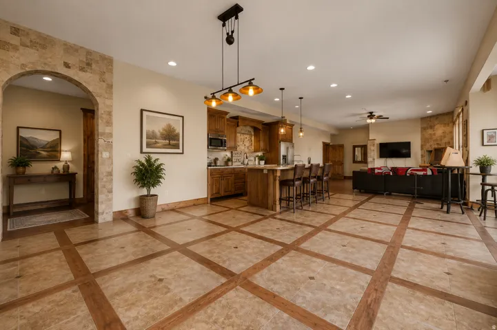 Expansive open-concept living area featuring a kitchen island with seating, recessed lighting, and a ceiling fan