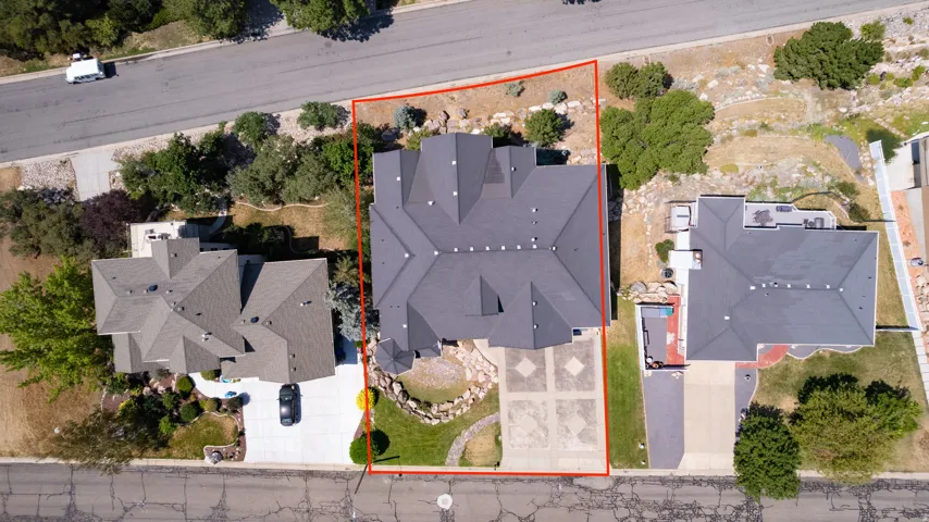 Property featuring a multi-gabled roofline, stone-edged landscaping, and a patterned driveway