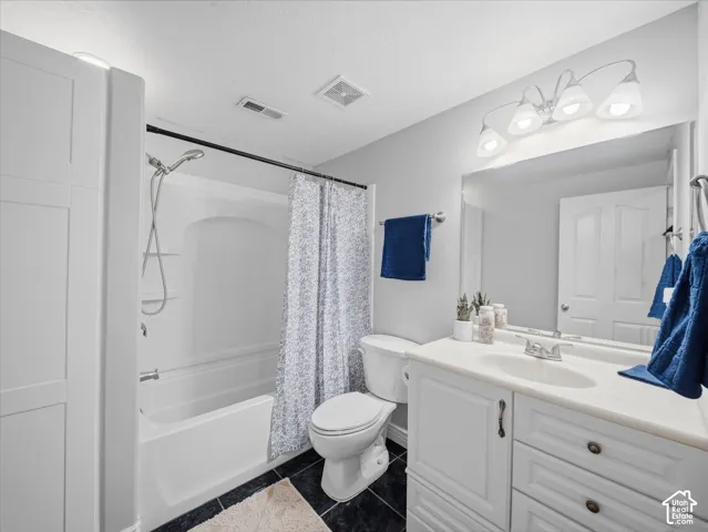 White vanity with integrated sink, chrome faucet, and bronze hardware