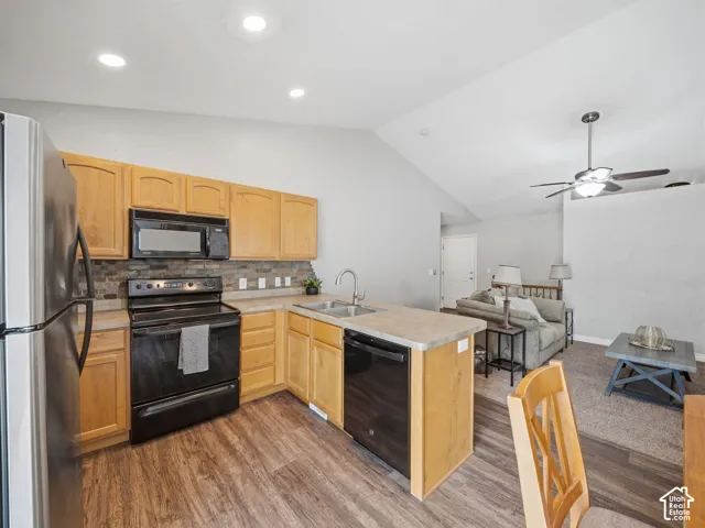 Kitchen featuring wood-finish flooring, light wood cabinetry, and stainless steel appliances