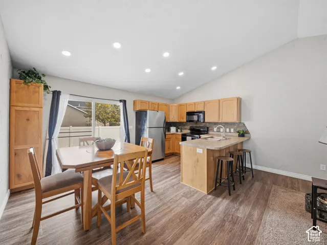 Kitchen with wood-finish cabinetry, stainless steel appliances, and a breakfast bar with seating