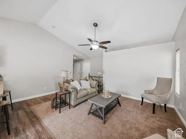Vaulted ceiling, ceiling fan with integrated lighting, wood-finish flooring, carpeting, and white trim