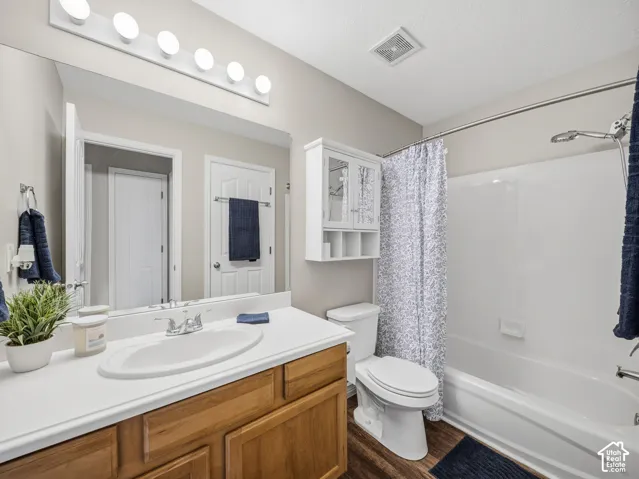 Bathroom featuring a single vanity with wood-finish cabinetry, white countertop, and an integrated sink
