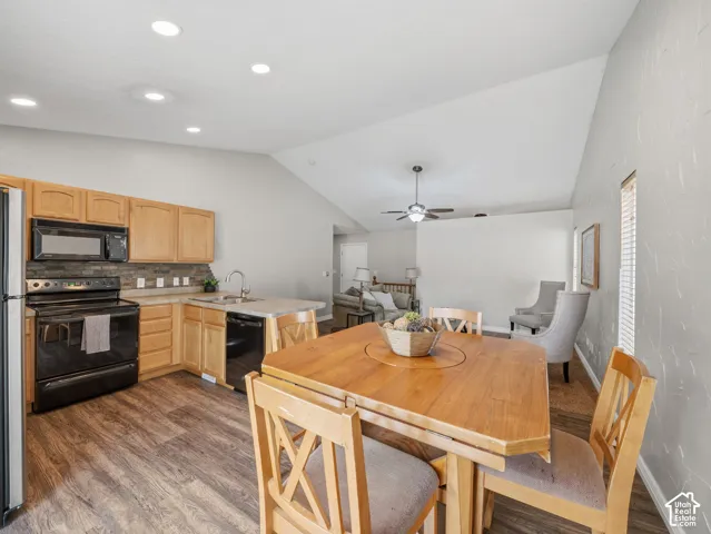 Kitchen featuring wood-finish flooring, stone-look backsplash, and a breakfast bar